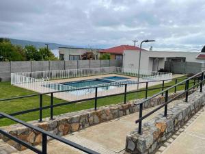a swimming pool with a fence next to a building at Hermoso departamento con vista al mar in Tomé