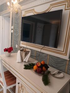 a table with a television and a bowl of fruit on it at Cardinale Resort in Iaşi