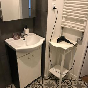 uma casa de banho com um lavatório branco e um espelho. em Apartament Warecka em Varsóvia
