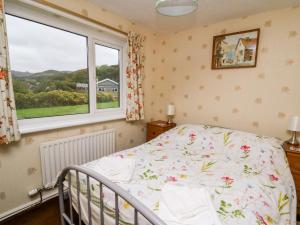 a bedroom with a bed and a window at Llwynon in Aberystwyth