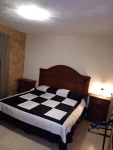 a bedroom with a black and white checkered bed at La Casa Rosa Guanajuato in Guanajuato