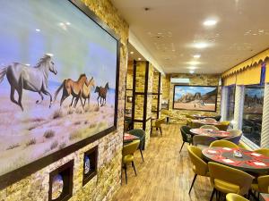 un restaurante con un mural de caballos en la pared en Petra Sella Hotel, en Wadi Musa