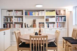 una cucina con tavolo, sedie e librerie di The Library by HolyGuest a Tel Aviv