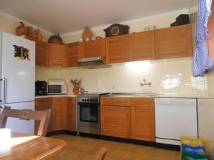 - une cuisine avec des placards en bois et un réfrigérateur blanc dans l'établissement Apartment In Moledo Beach, Caminha w/ Amazing Ocean View, à Caminha
