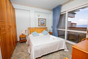 a bedroom with a bed and a large window at Residence Sole Dell'Argentario in Porto Santo Stefano