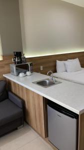 una cocina con fregadero y una cama en una habitación en HOTEL LOS ROBLES en Nuevo Laredo