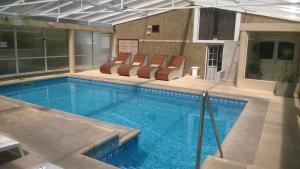 Una gran piscina con tumbonas en un edificio. en Casa Celeste, en Valeria del Mar