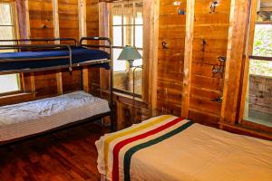 a room with two bunk beds in a cabin at Deer Hill Camp in Moultonborough