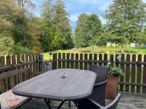 a wooden table and chairs on a deck with a fence at Die grüne Mitte in Pullenreuth