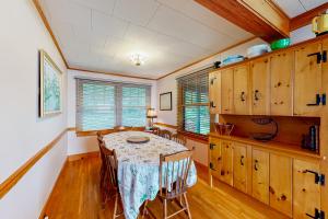 comedor con mesa y algunos armarios de madera en Alton Bay Lakefront Beauty en Alton Bay