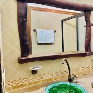 a bathroom with a sink with a mirror and a faucet at Hotel Hacienda Santa Barbara in San Gil