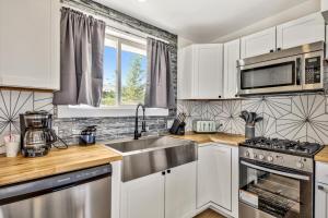 a kitchen with white cabinets and a stainless steel sink at The Historic West Walker Motel in Walker