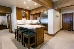 a kitchen with wooden cabinets and a large island with bar stools at Stein Eriksen Lodge Deer Valley in Park City