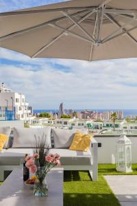 une terrasse avec deux canapés et une table avec des fleurs dans l'établissement Seascape Apartamento, à Finestrat