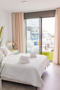 - une chambre avec un lit blanc et un balcon dans l'établissement Seascape Apartamento, à Finestrat