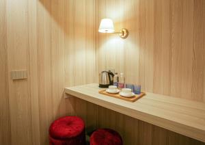 um quarto com um balcão com comodidades para preparar café e dois bancos vermelhos em The Venice Nest @ Ca' Del Duca em Veneza