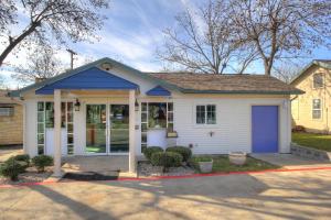 uma pequena casa branca com uma porta azul em Motel 6-Kerrville, TX em Kerrville