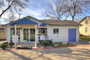 a small white house with a blue door at Motel 6-Kerrville, TX in Kerrville