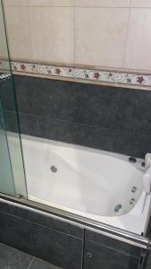 a bath tub in a bathroom with a glass door at Casa vero in San Antonio de Areco