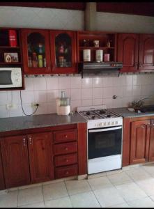 a kitchen with wooden cabinets and a stove top oven at Casa vero in San Antonio de Areco