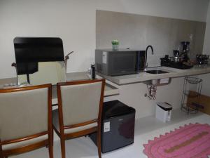 uma cozinha com um balcão com 2 cadeiras e um micro-ondas em ZANI APART HOTEL 520i em Porto Velho