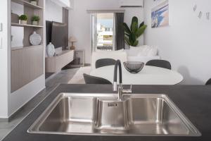 kuchnia ze zlewem ze stali nierdzewnej oraz salon w obiekcie Urban Chic luxury at the city center w Kalamácie +14 zdjęć