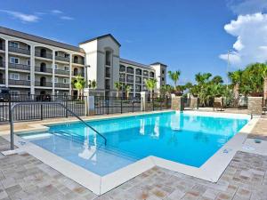a swimming pool in front of a building at Alerio B203 in Destin