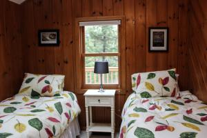 2 camas en una habitación con ventana en Waterfront Delight near Fish Cove, en Meredith