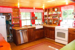 a kitchen with wooden cabinets and a white appliances at Cottage on Geneva Point in Moultonborough