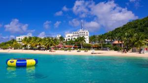 una balsa amarilla y azul en el agua junto a una playa en Caribic House en Montego Bay