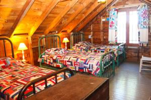 a room with three beds in a wooden cabin at Cottage on Geneva Point in Moultonborough