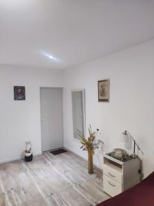 a white room with a vase on a wooden floor at DEPARTAMENTO MONO AMBIENTE in Reconquista