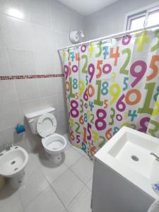 a bathroom with a toilet and a shower curtain with numbers at DEPARTAMENTO MONO AMBIENTE in Reconquista