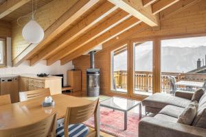 een keuken en woonkamer met een tafel en stoelen bij Alpengarten 7 in Bettmeralp
