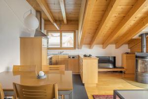 een keuken met houten plafonds en een tafel en stoelen bij Alpengarten 7 in Bettmeralp +21 foto's
