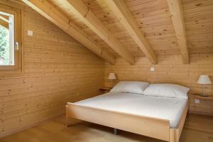 ベットマーアルプにあるAlpengarten 7の木製の部屋にベッド1台が備わるベッドルーム1室があります。