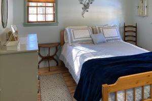 um quarto com uma cama, uma mesa e uma janela em Captivating Patrician Shores Cottage em Meredith