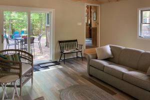 sala de estar con sofá y mesa en Captivating Patrician Shores Cottage, en Meredith