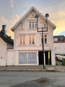 una casa blanca con una luz de la calle delante de ella en The Black Door. en Stavanger