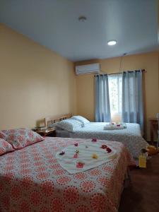 a bedroom with two beds with flowers on them at Hotel y Restaurante Virgen de Fátima in La Ceiba +10 photos