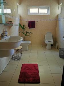 a bathroom with a sink and a toilet at L'Address Bar-Piscine-Restaurant in Cotonou
