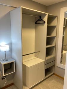 a closet with white shelves and a lamp on a table at Alberti Desing in San Carlos de Bariloche