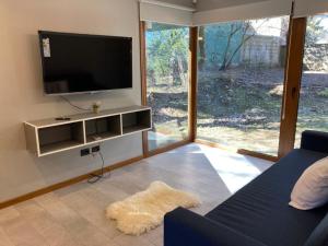 a living room with a flat screen tv and a couch at Alberti Desing in San Carlos de Bariloche