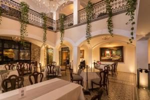 普埃布拉的住宿－瑪麗亞卡索納酒店，一间带桌椅和吊灯的餐厅