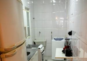 a small white bathroom with a sink and a toilet at Quarto e sala em Ipanema perto da praia in Rio de Janeiro
