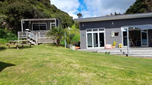 ein Haus mit einem großen Garten davor in der Unterkunft Marina Vista Cabin in Tutukaka