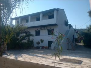 a white house with a lot of plants in front of it at Villa Lucia in Agios Georgios Pagon