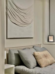 Un dormitorio con una cama con almohadas y una pintura en The Black Door. en Stavanger