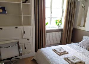 - une chambre avec un lit, une fenêtre et une chaise dans l'établissement Royal Warsaw Apartment, à Varsovie