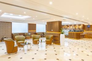 a lobby of a hotel with chairs and a bar at Golden Sands Suites in Dubai